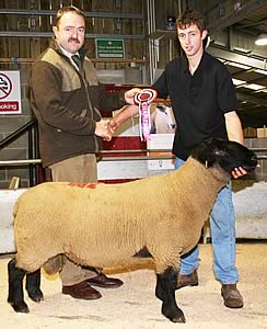 With his Skipton multi-breed Suffolk champion Stephen Bolland, right, receives the victor’s spoils from judge Craig Bradbury, Diggle.