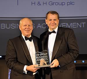 Richard Atkinson Vice-Chairman of Cumberland Building Society presenting the award to H&H Group Chief Executive Brian Richardson